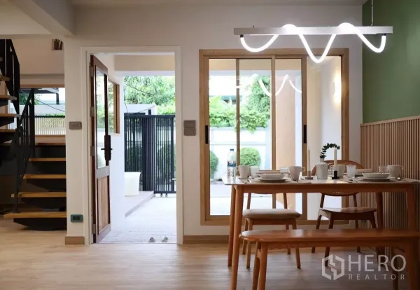 ทาวน์เฮาส์ ให้เช่าในWatthana, Bangkok - โซนรับประทานอาหารเชื่อมลานบ้าน โต๊ะไม้และโคมไฟสมัยใหม่ ข้างบันไดวน