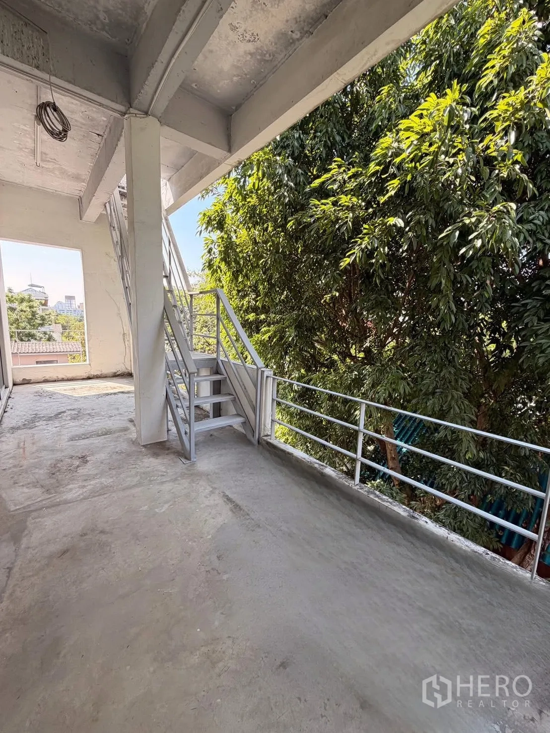 สำนักงานที่บ้าน for rent in Huai Khwang, Bangkok - ระเบียงคอนกรีตมีบันไดโลหะและราวกันตก ข้างต้นไม้ใหญ่