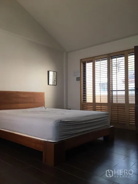 ทาวน์เฮาส์ ให้เช่าในKhlong Toei, Bangkok - ห้องนอนเตียงไม้ ประตูระเบียงบานเกล็ดไม้