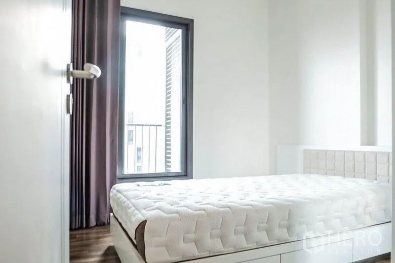 คอนโด ให้เช่าในKhlong Toei, Bangkok - ห้องนอนสว่างพร้อมหน้าต่างบานใหญ่ ม่านทึบ และเตียงพื้นยก