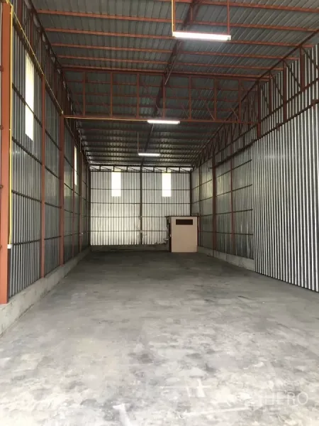 货栈 出租在Bueng Kum, Bangkok - 高挑钢结构仓库内景，混凝土地面、金属板墙，后方有小型机房。