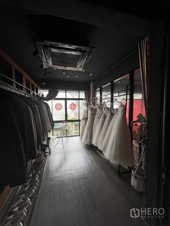 零售空间 出租在Watthana, Bangkok - 长廊两侧挂西装与礼服，上方为嵌入式空调。
