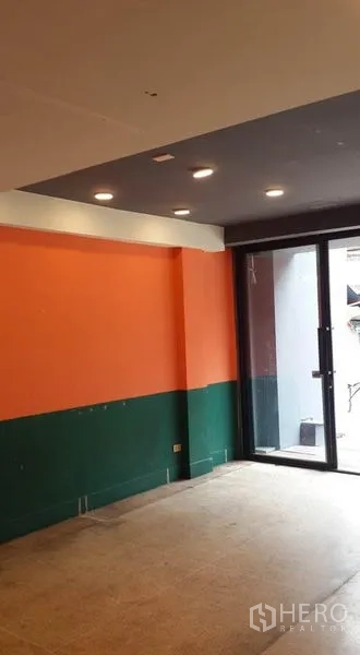 店屋 出租在Bang Khen, Bangkok - 一层视角，推拉玻璃门与彩色墙面，天花射灯。