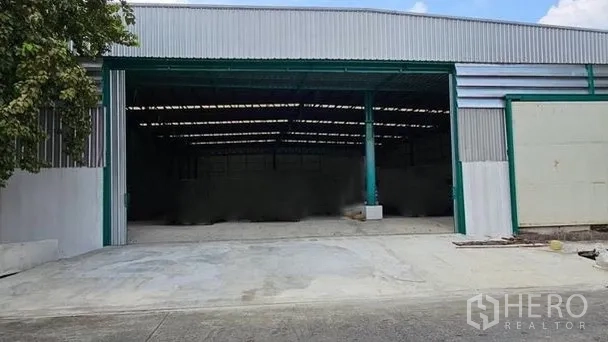 คลังสินค้า ให้เช่าในBang Bon, Bangkok - ทางเข้าโกดังกว้าง เสาโครงเหล็กสีเขียว พร้อมลานคอนกรีตรับส่งสินค้า