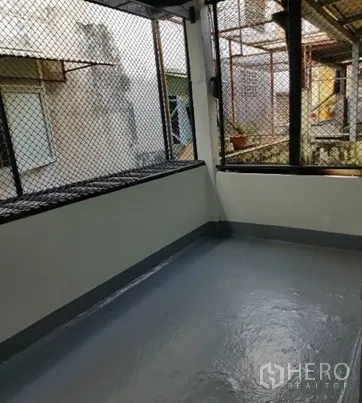 店屋 出租在Watthana, Bangkok - 后阳台半封闭，金属网与涂层地面。