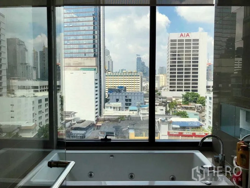 公寓 出租在Bang Rak, Bangkok - 浴缸靠大幅落地窗，可眺望曼谷城市景观。