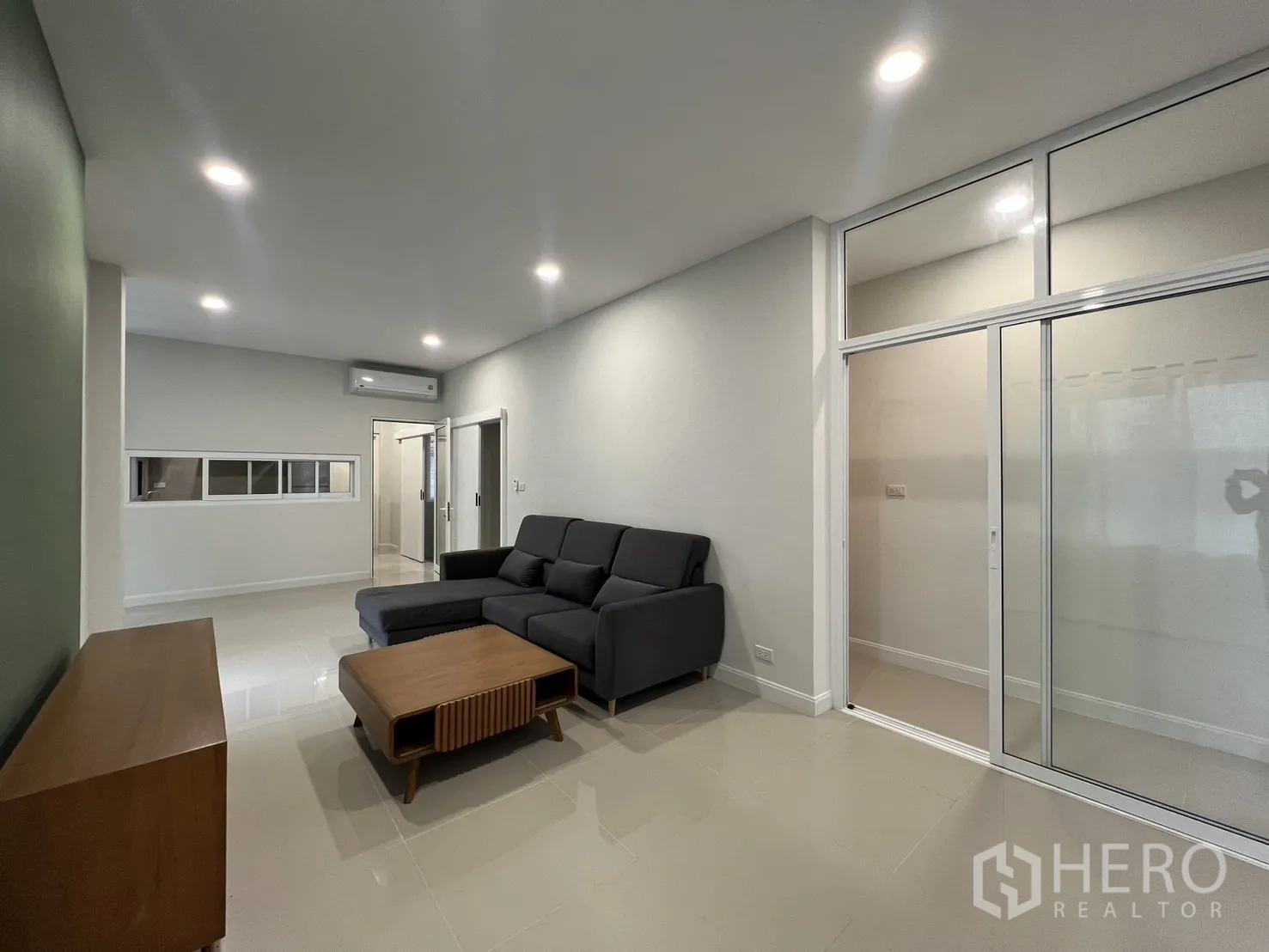 Detached House for rent in Saphan Sung, Bangkok - Living room with sliding glass partition, recessed lights and air conditioning.