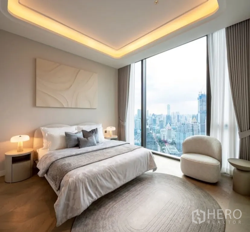 公寓 出租或出售在Pathum Wan, Bangkok - 卧室配落地景观窗与暖色灯槽天花，远眺天际线。