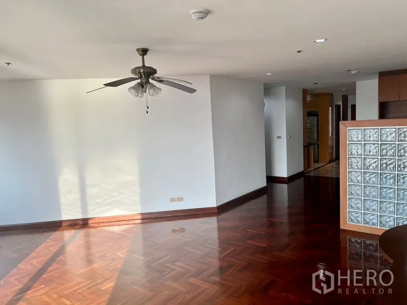 คอนโด ให้เช่าในBang Kho Laem, Bangkok - โถงนั่งเล่นกว้าง พื้นปาร์เกต์ พัดลมเพดาน และผนังกระจกบล็อก