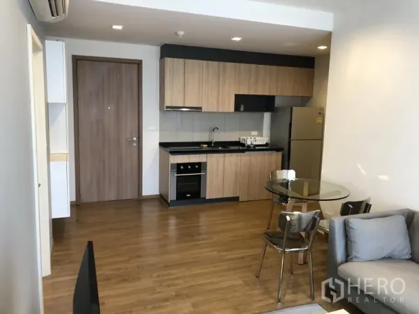 公寓 出租在Watthana, Bangkok - 开放式厨房，木质橱柜，嵌入式灶台与烤箱，配大冰箱。