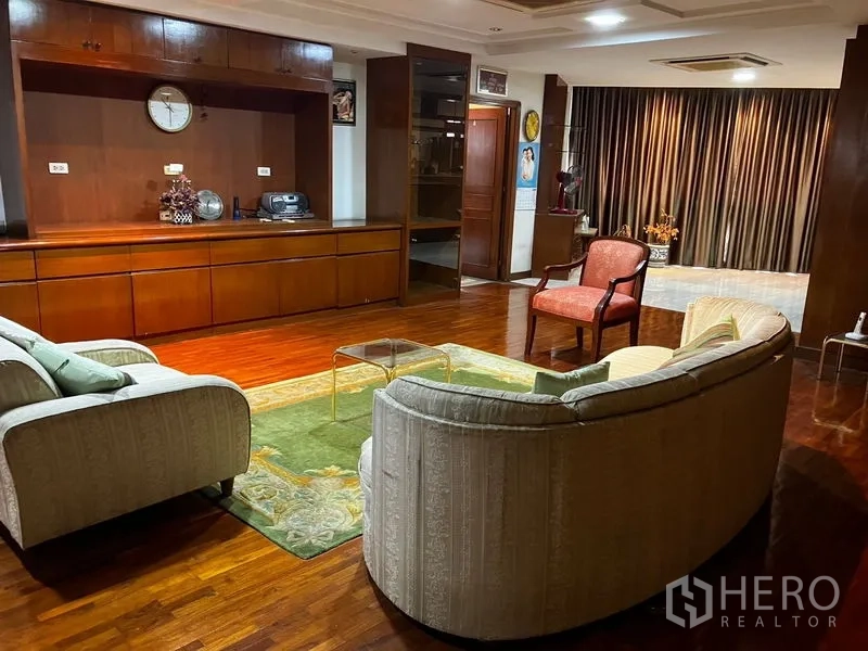 คอนโด ให้เช่าหรือขายในKhlong Toei, Bangkok - พื้นที่นั่งเล่นกว้าง ตู้บิลท์อิน พรม และเก้าอี้เดี่ยว บนพื้นไม้เงา