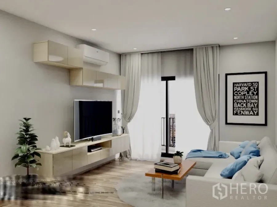 Condominium for rent or sale in Watthana, Bangkok - Bright living room with L-shaped sofa, floating TV cabinet, wood floors, and balcony doors with sheer curtains in a Bangkok condo.