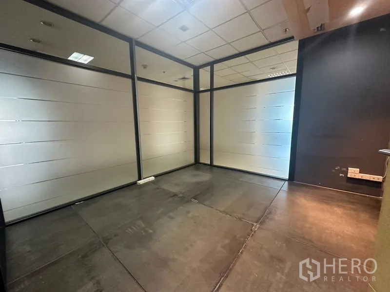 Office Space for rent in Khlong Toei, Bangkok - Compact office with frosted glass partitions and dark tiled flooring.