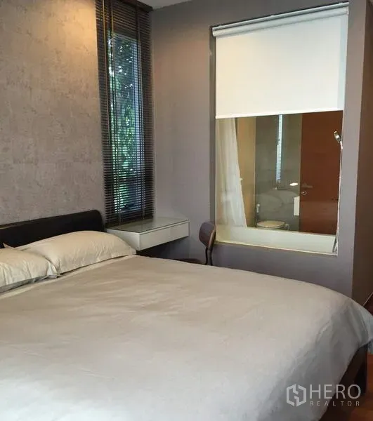 คอนโด ให้เช่าในKhlong Toei, Bangkok - ห้องนอนอบอุ่น เตียงขนาดใหญ่ หน้าต่างกระจกเชื่อมห้องน้ำพร้อมมู่ลี่ และหน้าต่างบานเกล็ดวิวต้นไม้