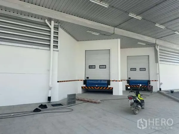Warehouse for rent in Bang Phli, Samut Prakan - Two dock-high loading bays with dock levelers and roller shutter doors under a roof.