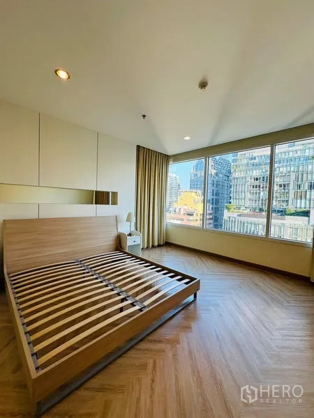 公寓 出租在Bang Rak, Bangkok - 转角主卧，宽幅观景窗与木地板。