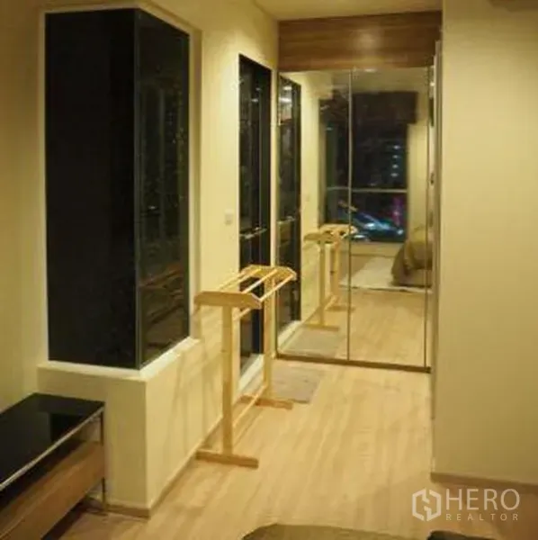 Condominium for rent in Sathon, Bangkok - Walk-through closet with mirrored wardrobes and wood flooring in a Bangkok condominium.