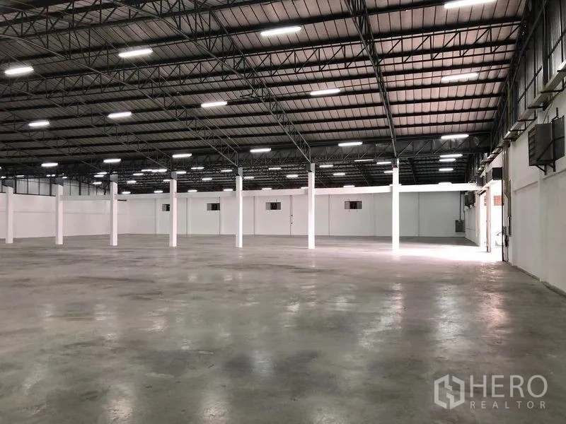 Warehouse for rent in Pak Kret, Nonthaburi - Interior view toward loading door with column structure and ample natural and artificial light.