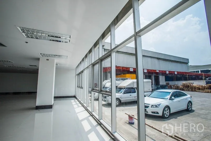 สำนักงาน ให้เช่าในBang Phli, Samut Prakan - ผนังกระจกยาวภายในออฟฟิศ มองออกไปยังลานอุตสาหกรรมและรถจอด