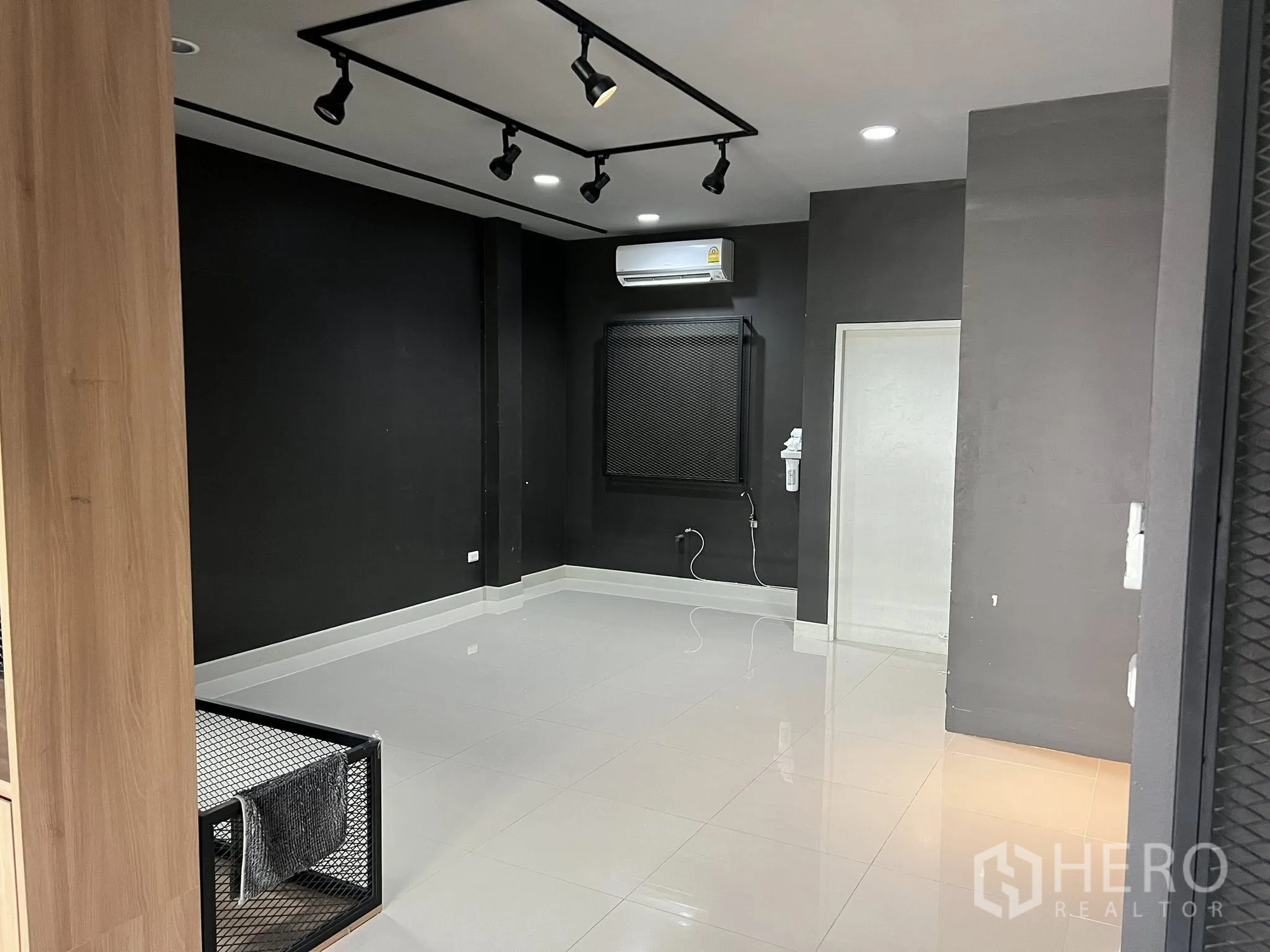 Detached House for rent or sale in Don Mueang, Bangkok - Black feature wall room with glossy white tiles and ceiling lights.
