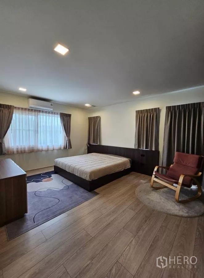 บ้าน ให้เช่าในBang Phli, Samut Prakan - ห้องนอนใหญ่กว้าง เตียงคู่ ผ้าม่าน และเก้าอี้นั่งพัก