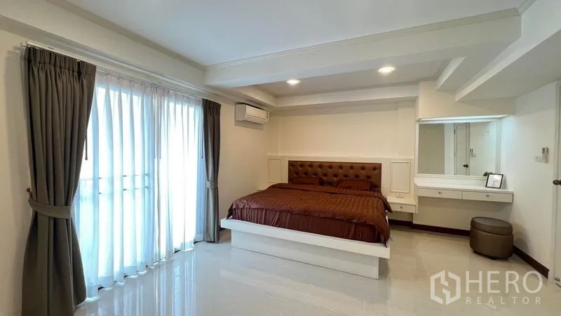 公寓 出租在Phra Khanong, Bangkok - 明亮卧室，阳台落地门、软包床头与内置梳妆台