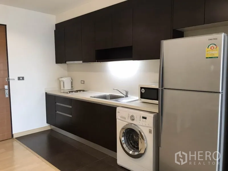 คอนโด ให้เช่าหรือขายในWatthana, Bangkok - ครัวยุคใหม่ตู้ลอยสีเข้ม พร้อมอ่างล้างจาน เครื่องซักผ้า และตู้เย็น