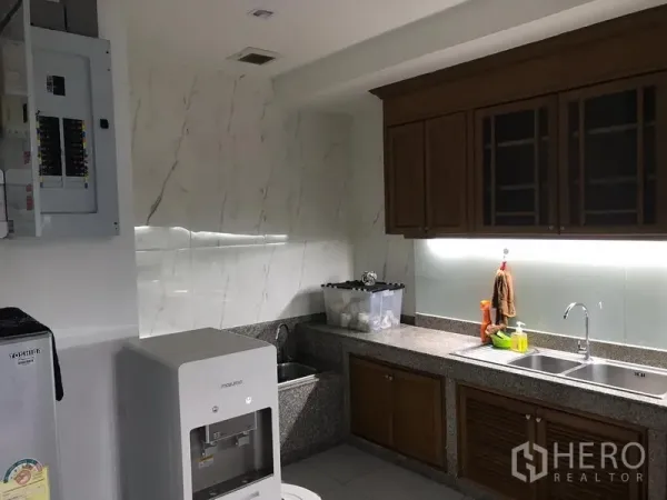 Office Space for rent in Khlong Toei, Bangkok - Office pantry with granite countertops, double sink, wooden cabinets and a water dispenser.