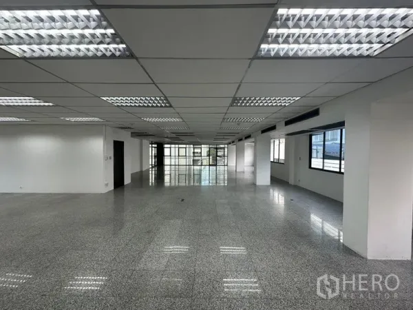 สำนักงาน ให้เช่า - พื้นที่สำนักงานยาวต่อเนื่อง ฝ้าทีบาร์พร้อมดวงไฟ หน้าต่างด้านข้าง และพื้นผิวมันเงา