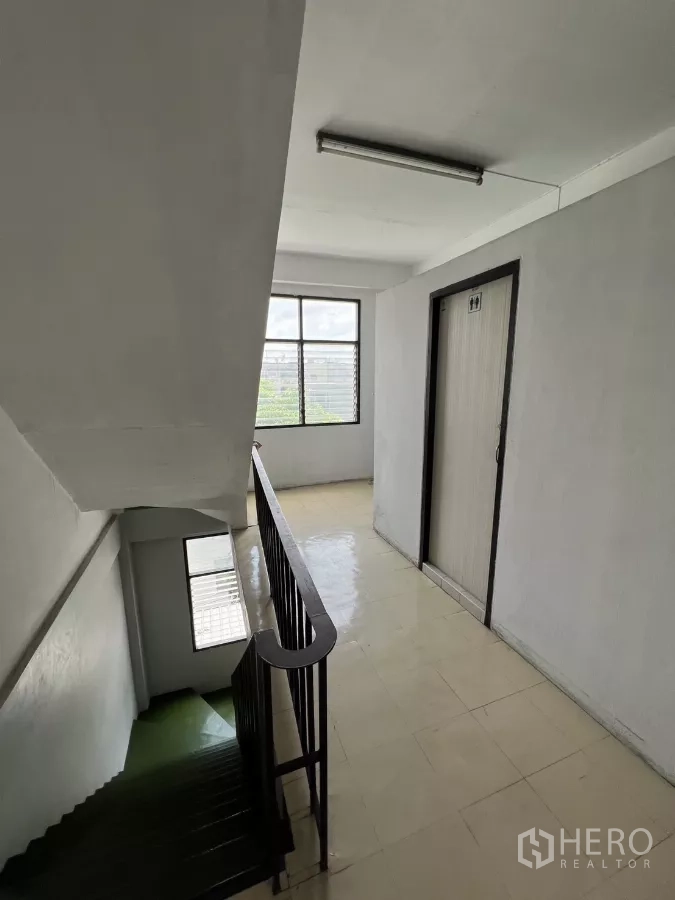 店屋 出租在Watthana, Bangkok - 楼梯平台，金属扶手与采光窗。