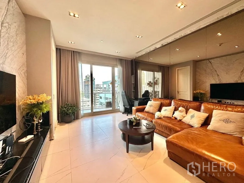 Condominium for rent in Pathum Wan, Bangkok - Sunlit lounge with floor-to-ceiling windows and city skyline beyond the balcony.