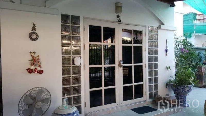 Detached House for rent in Bang Kapi, Bangkok - Covered front patio with glass-paneled double doors and potted plants.