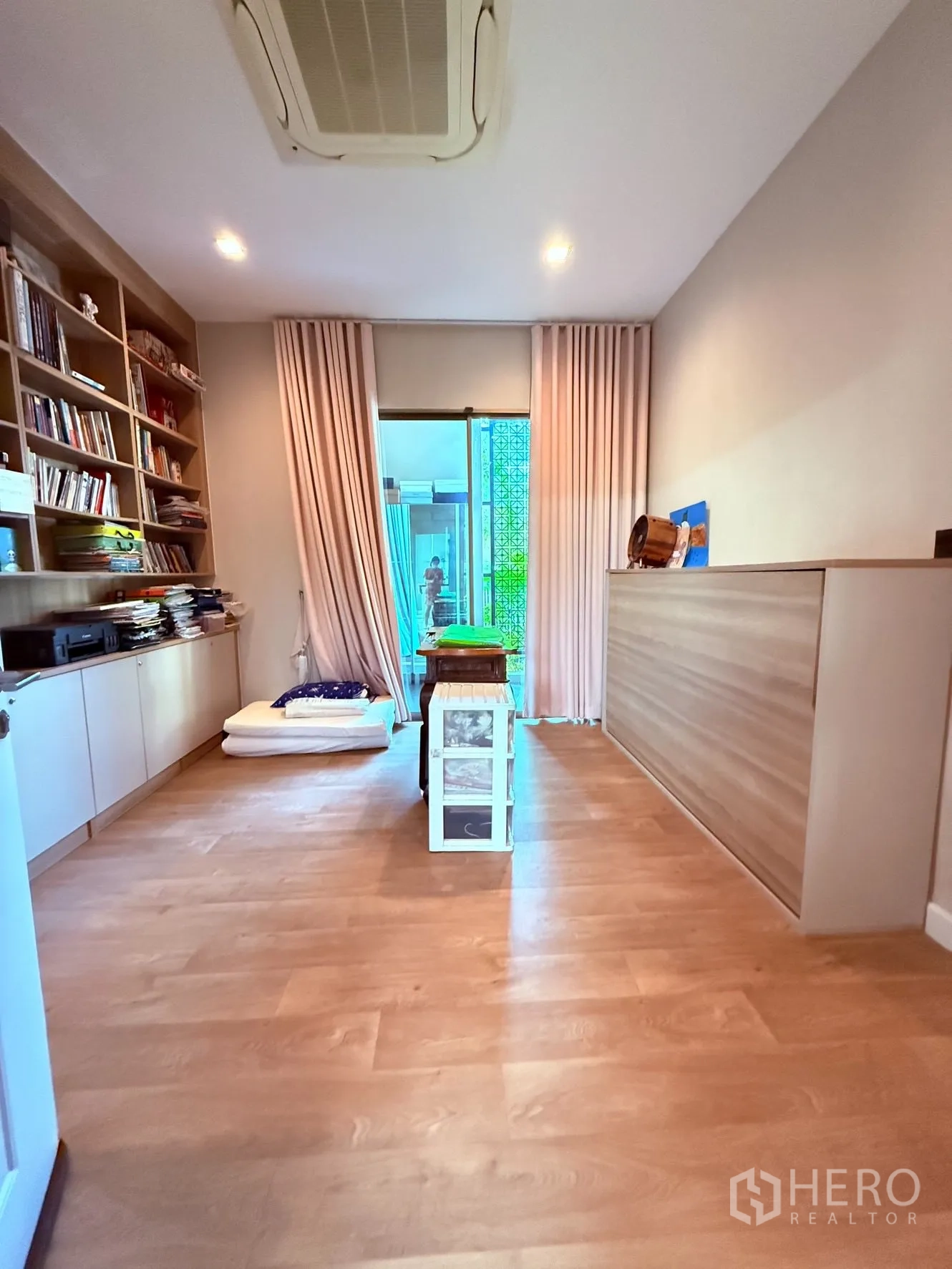 บ้านเดี่ยว for rent or sale in Prawet, Bangkok - ห้องอเนกประสงค์พร้อมชั้นหนังสือบิลท์อิน พื้นไม้ และประตูกระจกสไลด์ออกลานเล็ก.