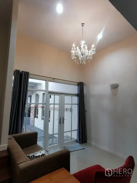 สำนักงานที่บ้าน ให้เช่าในChatuchak, Bangkok - โถงรับแขกเพดานสูงพร้อมโคมระย้าและประตูกระจกบานใหญ่เปิดสู่ระเบียง