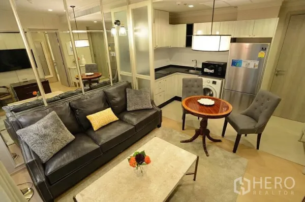 คอนโด ให้เช่าหรือขายในWatthana, Bangkok - พื้นที่นั่งเล่นแบบเปิด โซฟาหนัง โต๊ะกินข้าวกลม พร้อมครัวบิลท์อิน ตู้เย็น เตาไมโครเวฟ และเครื่องซักผ้า