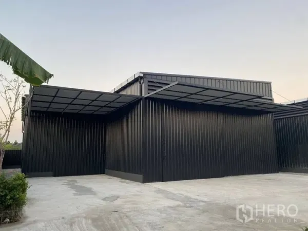 Warehouse for rent in Wang Thonglang, Bangkok - Side view of the warehouse with extended loading bay roof and ample driveway for trucks.