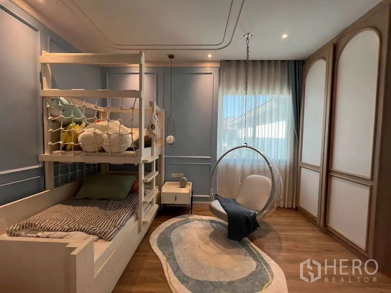 Detached House for sale in Saphan Sung, Bangkok - Kids’ bedroom with bunk bed, blue paneled walls and a hanging bubble chair.