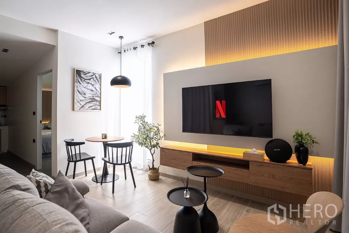 บ้าน ให้เช่าในHuai Khwang, Bangkok - พื้นที่นั่งเล่นสว่าง ผนังทีวีตกแต่ง ผ้าม่านโปร่ง และชุดโต๊ะกลม