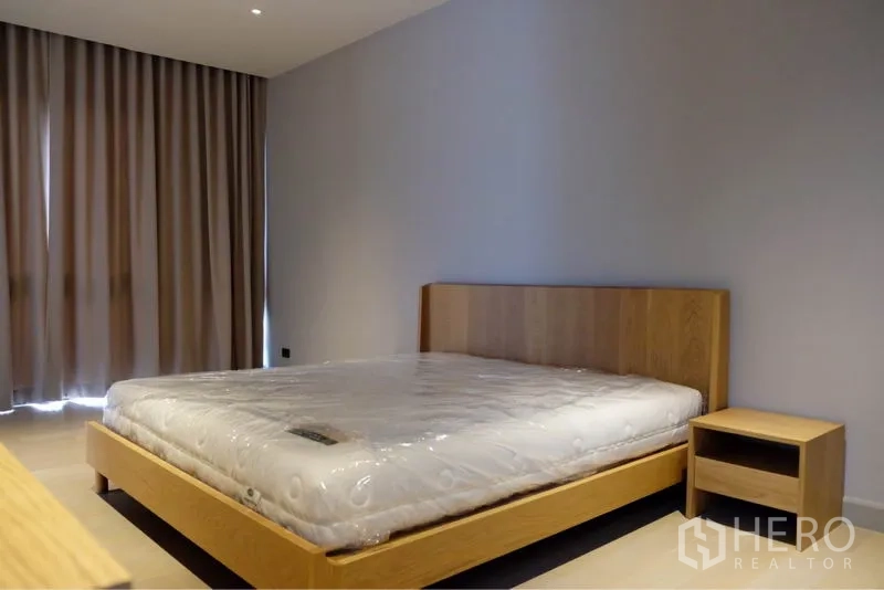 บ้าน ให้เช่าในWatthana, Bangkok - ห้องนอนเรียบง่าย เตียงไม้พร้อมโต๊ะข้าง ม่านทึบตลอดผนัง