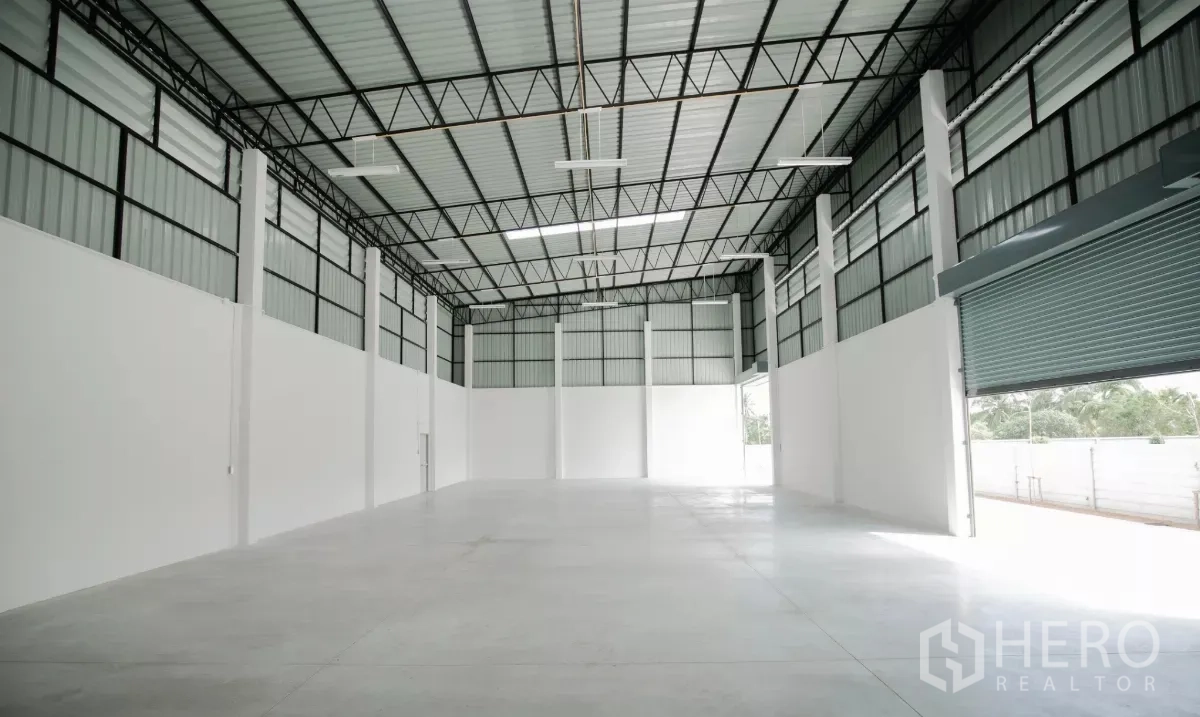 Factory for rent or sale in Nakhon Pathom - Open production hall featuring tall columns, insulated roof panels and roller door.