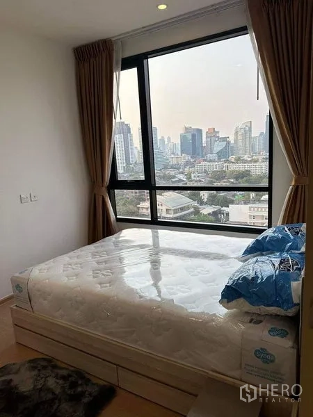 คอนโด ให้เช่าในWatthana, Bangkok - ห้องนอนสว่างพร้อมหน้าต่างบานใหญ่เห็นวิวสกายไลน์กรุงเทพฯ เตียงควีนและผ้าม่านทึบแสง