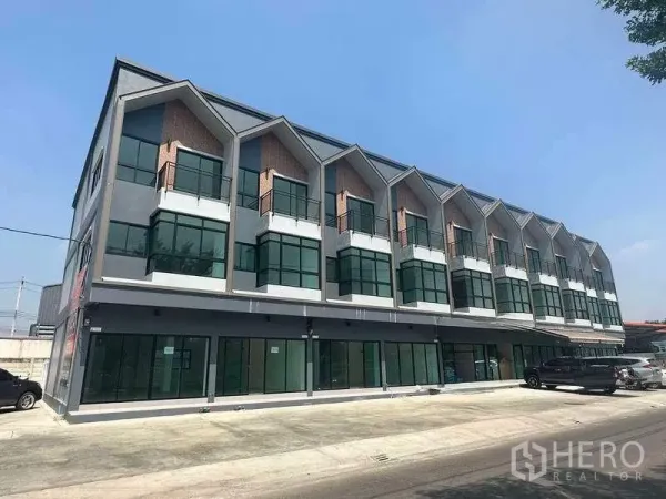 Home Office for sale in Bang Yai, Nonthaburi - Modern three-storey home office block with full-height glass facade and front parking under a clear sky in Bang Yai.