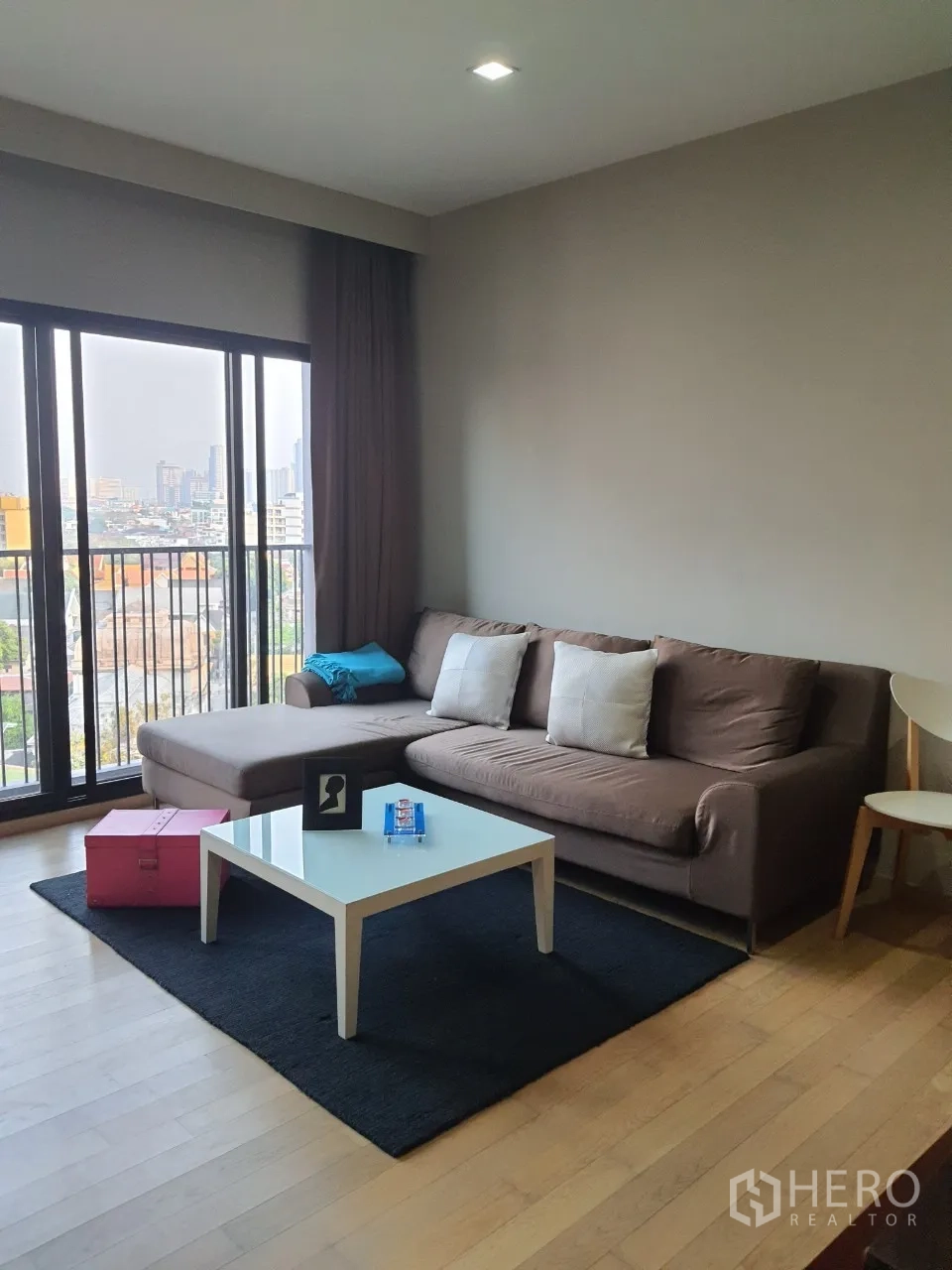 คอนโด ให้เช่าในWatthana, Bangkok - มุมนั่งเล่นพร้อมโซฟารูปตัวแอล โต๊ะกลางสีขาว และหน้าต่างบานใหญ่ในคอนโดเอกมัย