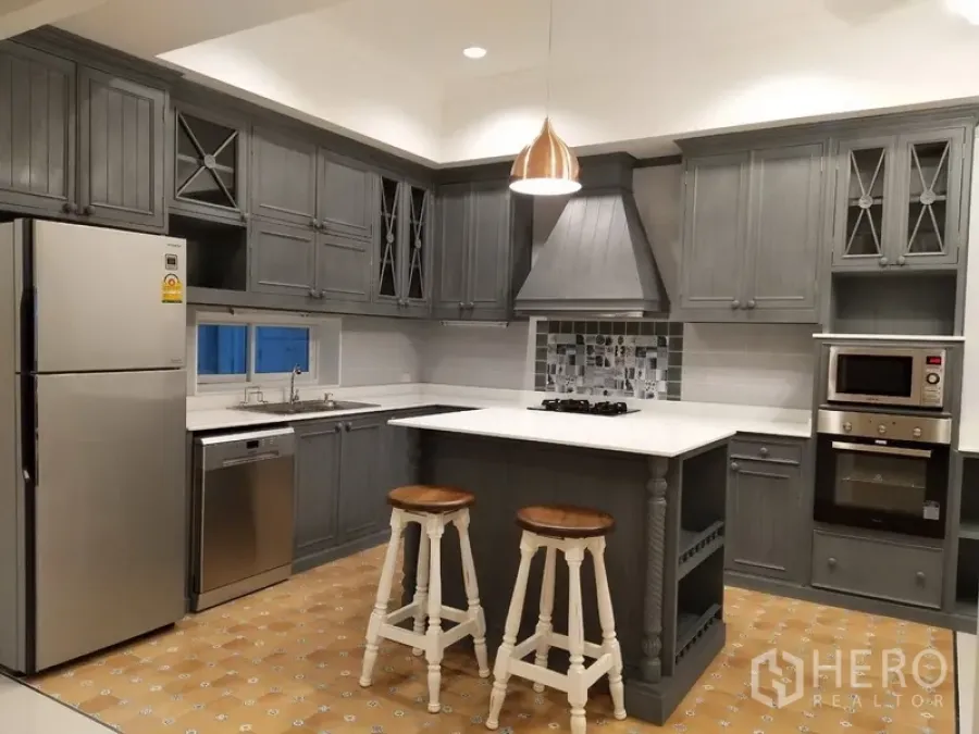 联排别墅 出租在Mueang Samut Prakan, Samut Prakan - 灰色现代厨房，带岛台、燃气灶、吊灯和不锈钢电器。