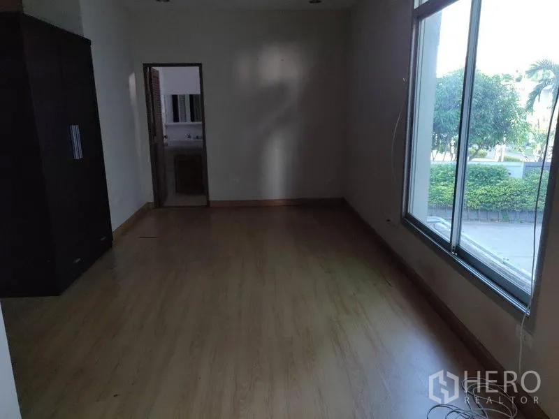 Home Office for rent in Watthana, Bangkok - Bedroom with large window, wardrobe, and access to an ensuite.