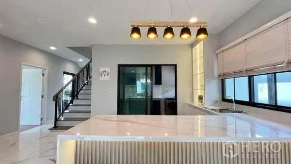 บ้านเดี่ยว for rent or sale in Bang Phli, Samut Prakan - ไอส์แลนด์ครัวใต้โคมไฟ ใกล้บันไดและประตูกระจกบานเลื่อน