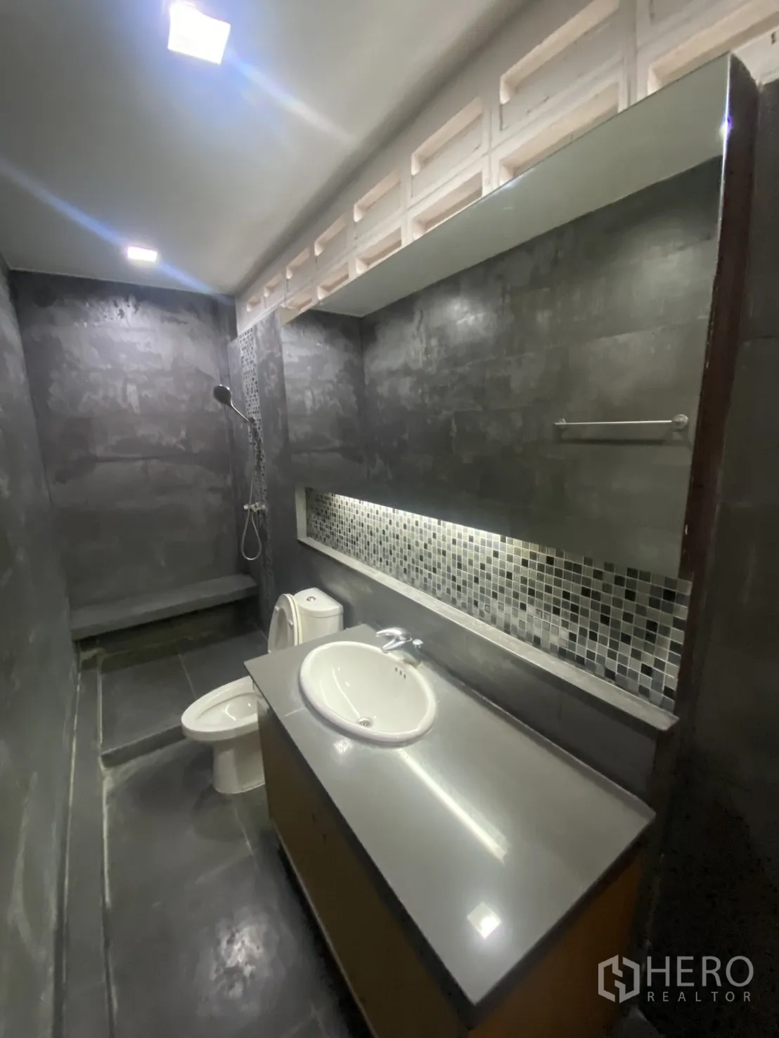 Shophouse for rent in Bang Rak, Bangkok - Modern bathroom with shower, long vanity, and dark polished tiles.