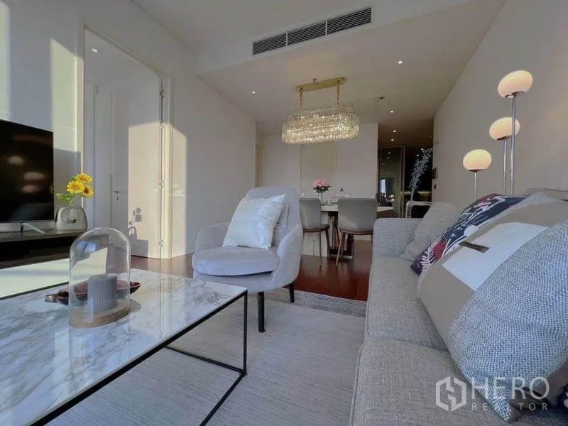 公寓 出租在Watthana, Bangkok - 起居与餐区，一盏水晶吊灯和落地灯点缀其中。