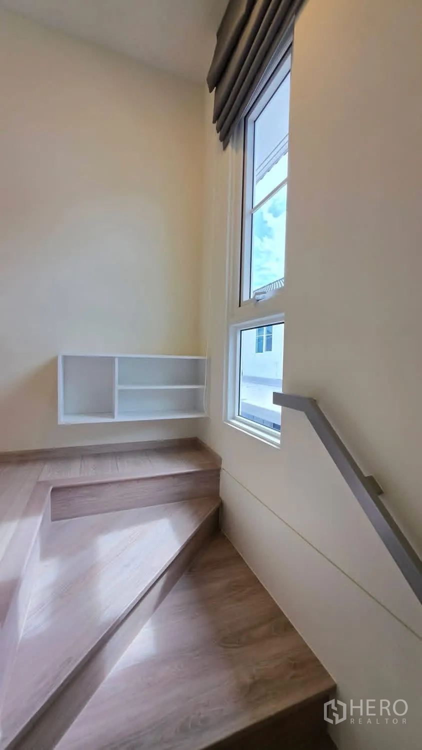 Detached House for rent in Bang Phli, Samut Prakan - Stair landing with large window, built-in shelves, and natural light.