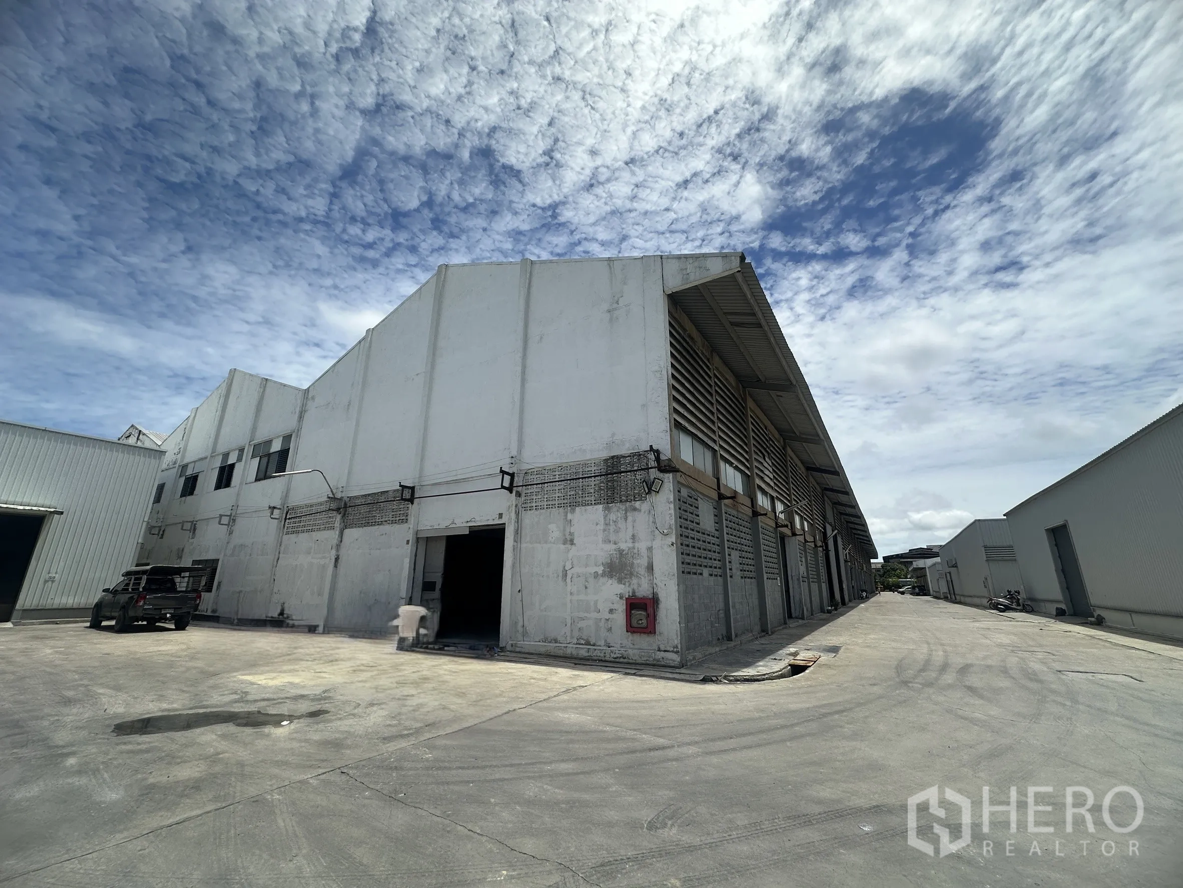 Factory for rent in Mueang Samut Prakan, Samut Prakan - Exterior of the industrial building with a wide driveway suitable for trucks.